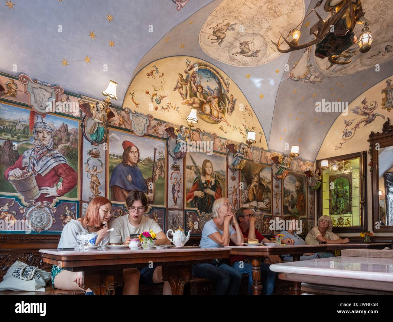 I clienti siedono sotto affreschi decorati in stile rinascimentale e pitture murali all'interno della pasticceria Konditorei Kormuth a Bratislava, Slovacchia. Foto Stock