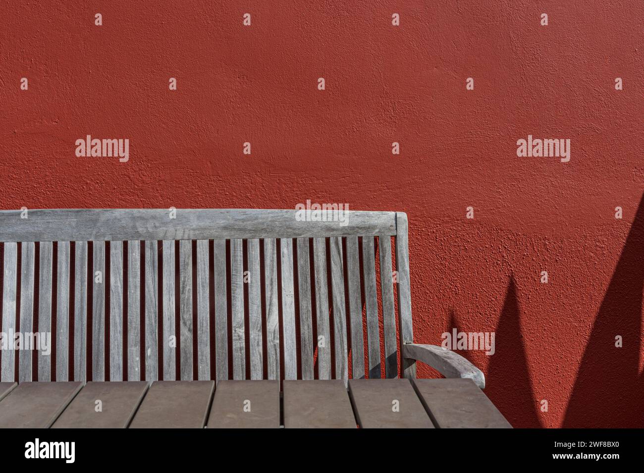 Tavolo e sedia in legno contro parete ruvida rossa, Curacao Foto Stock