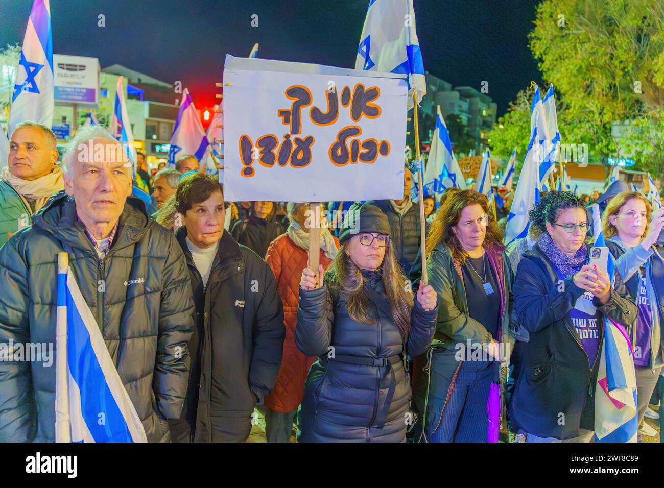 Haifa, Israele - 27 gennaio 2024: Persone con vari segni e bandiere che protestano contro il governo, chiedendo di assumersi la responsabilità della guerra Foto Stock
