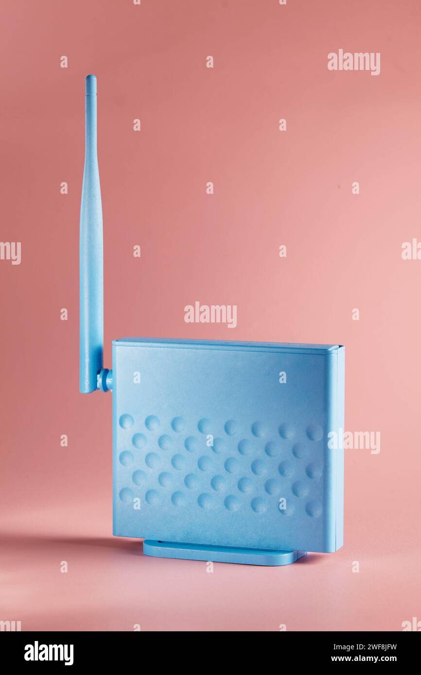 Un router blu su sfondo rosa Foto Stock