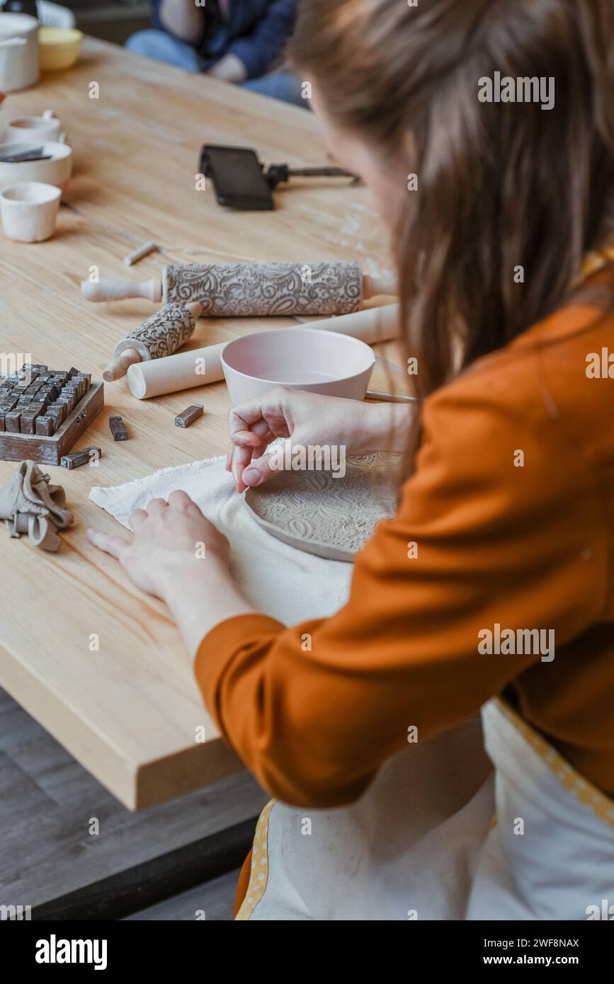 Stampaggio a mano in argilla bianca, Potter stampò un piatto traforato Foto Stock