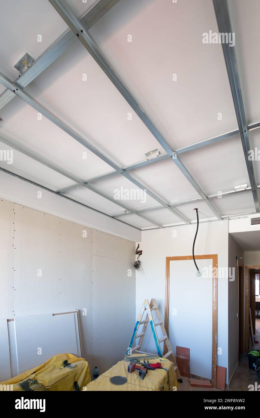 Ristrutturazione di una casa con isolamento in cartongesso nei soffitti e pareti parzialmente costruite con la struttura metallica del soffitto visibile e. Foto Stock