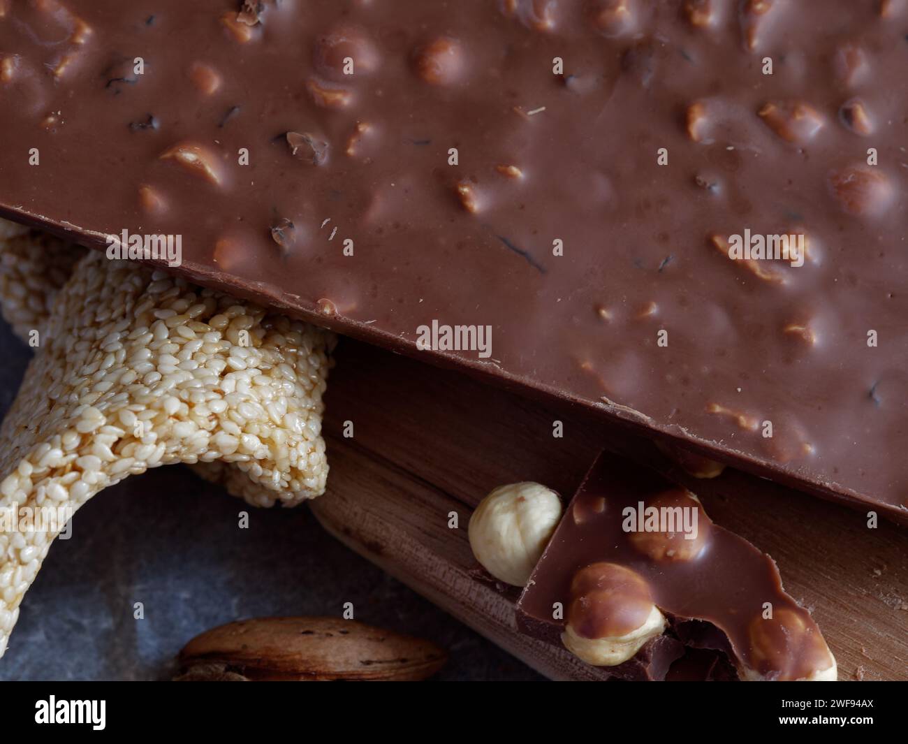 Un delizioso assortimento di noci e prelibatezze che si abbinano perfettamente a una ricca barretta di cioccolato Foto Stock