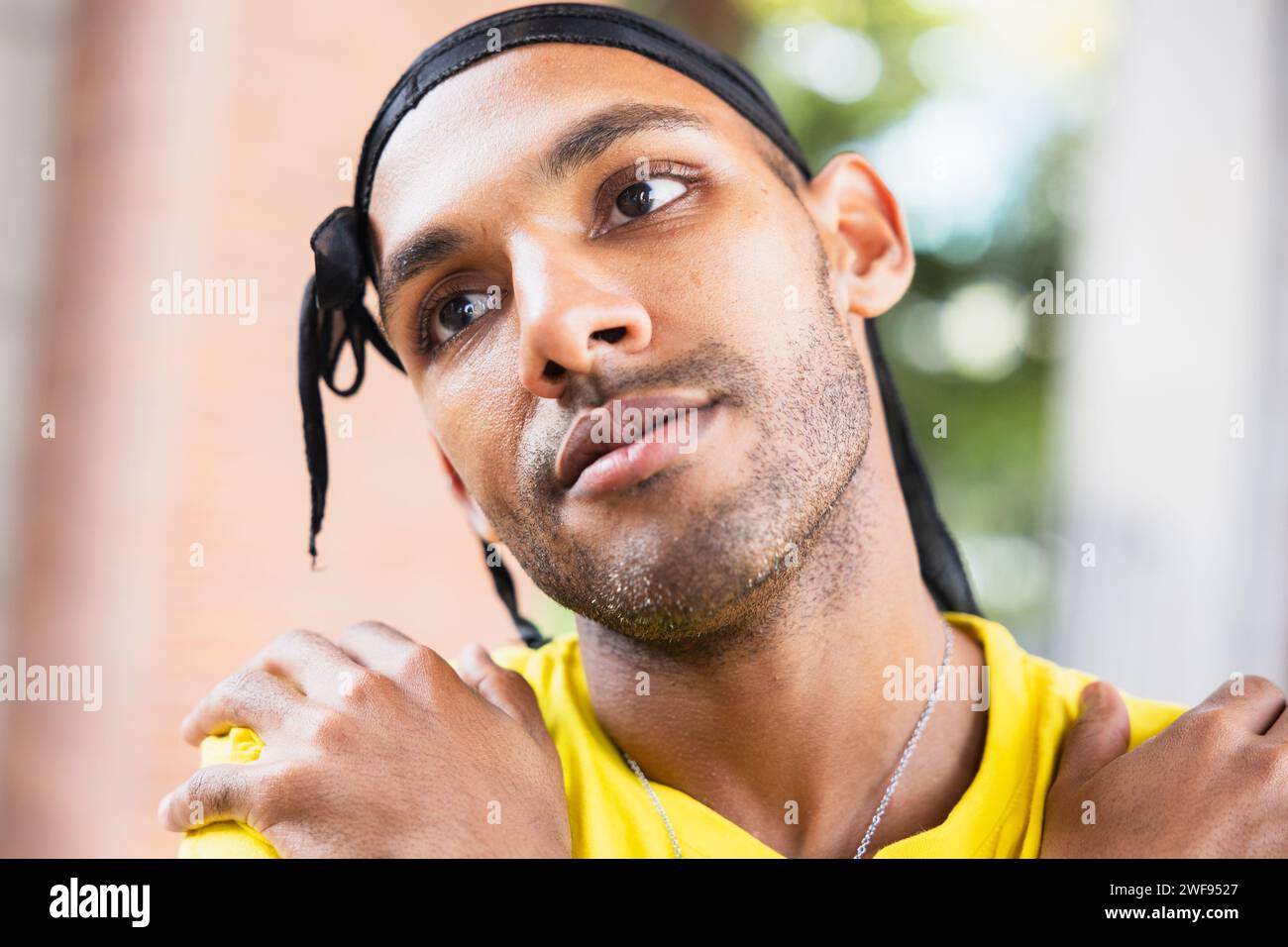 Un ritratto ravvicinato di un ballerino urbano maschile contemplativo all'aperto con uno sguardo mirato. Foto Stock