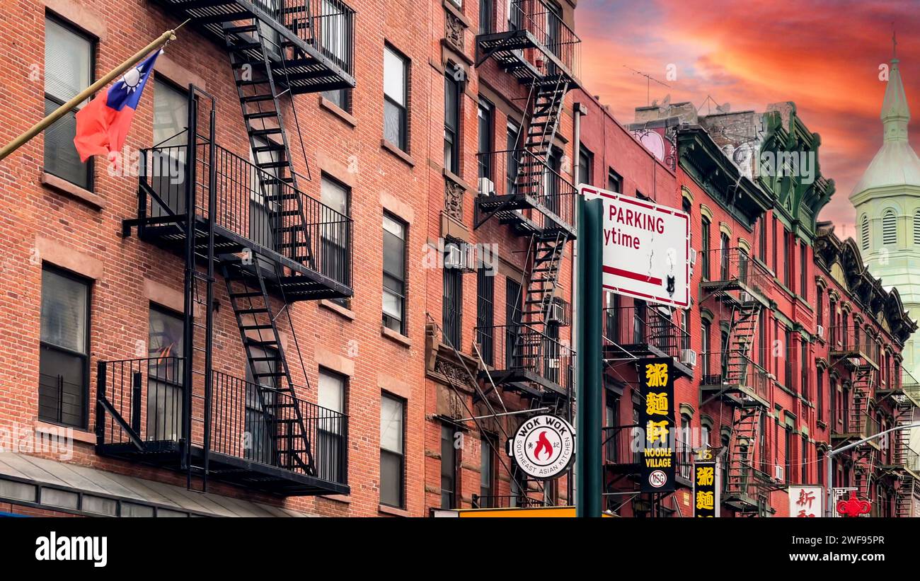 New York, USA; 4 gennaio 2024: Il famoso quartiere di Chinatown con marciapiedi fiancheggiati da negozi e i suoi edifici in mattoni rossi con scale di emergenza. Foto Stock