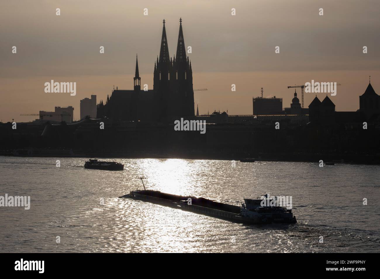 Il Reno con la cattedrale di Colonia sullo sfondo e due chiatte in primo piano Foto Stock