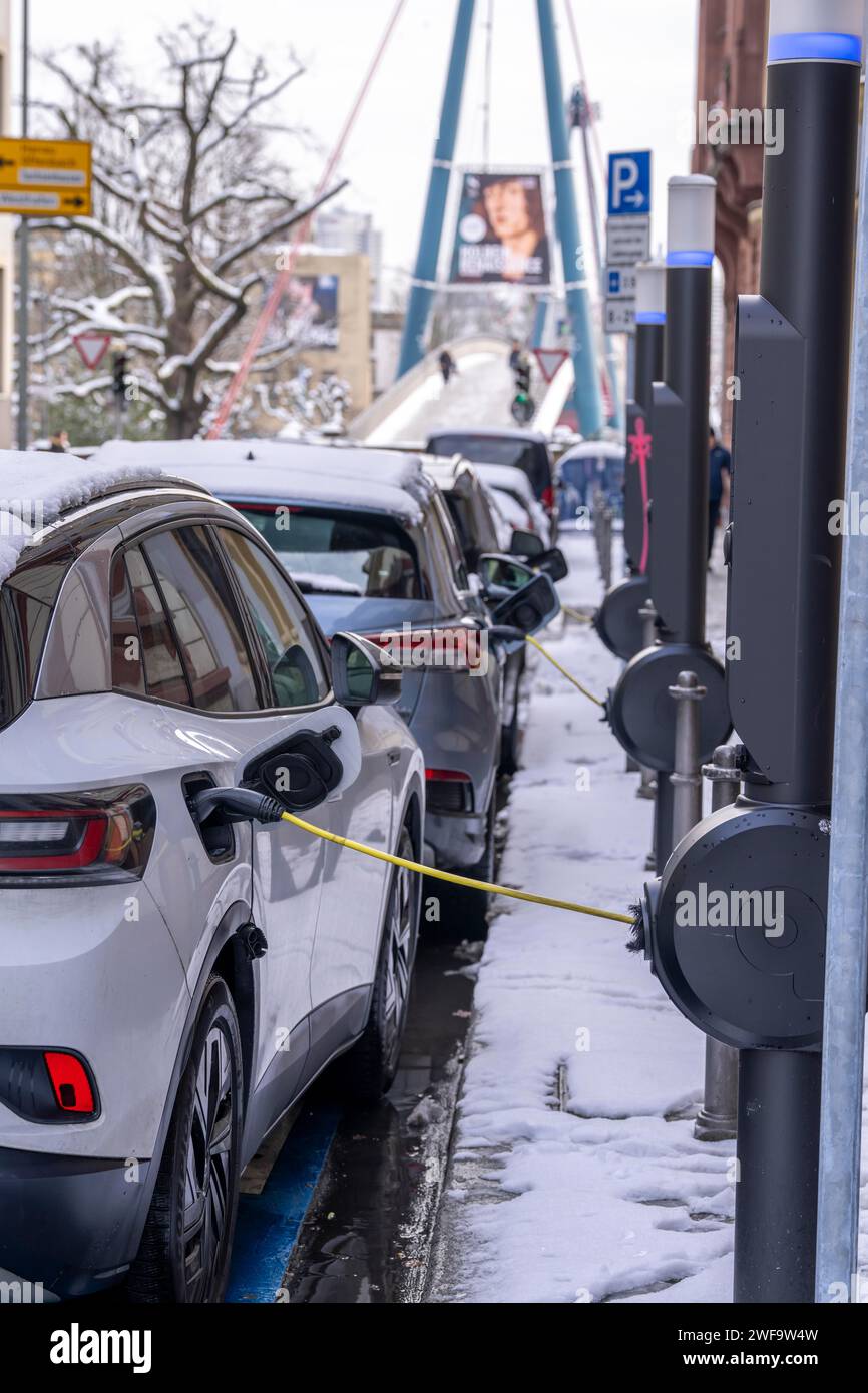 Inverno in città, le auto elettriche si ricaricano presso le stazioni di ricarica nel centro di Francoforte, Assia, Germania Foto Stock