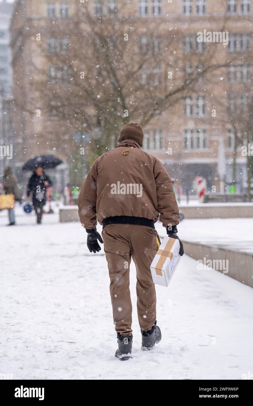 Inverno a Francoforte, il dipendente UPS porta un pacchetto al cliente, a piedi, a causa del clima invernale nel distretto bancario, Assia, Germania Foto Stock