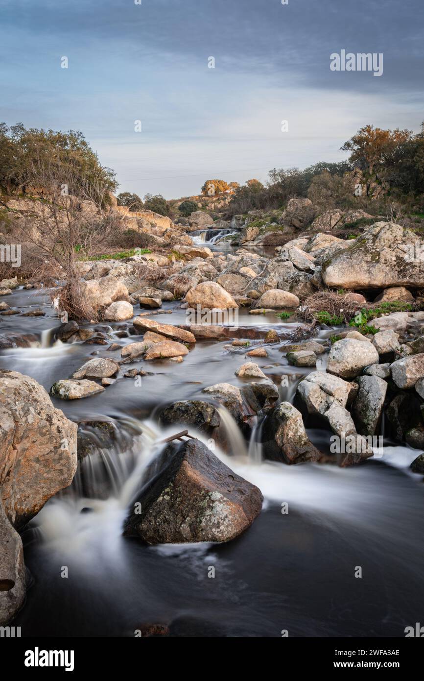 Il fiume Salor scorre verso il bacino idrico di El Gallo. Fotografia a lunga esposizione. Foto Stock