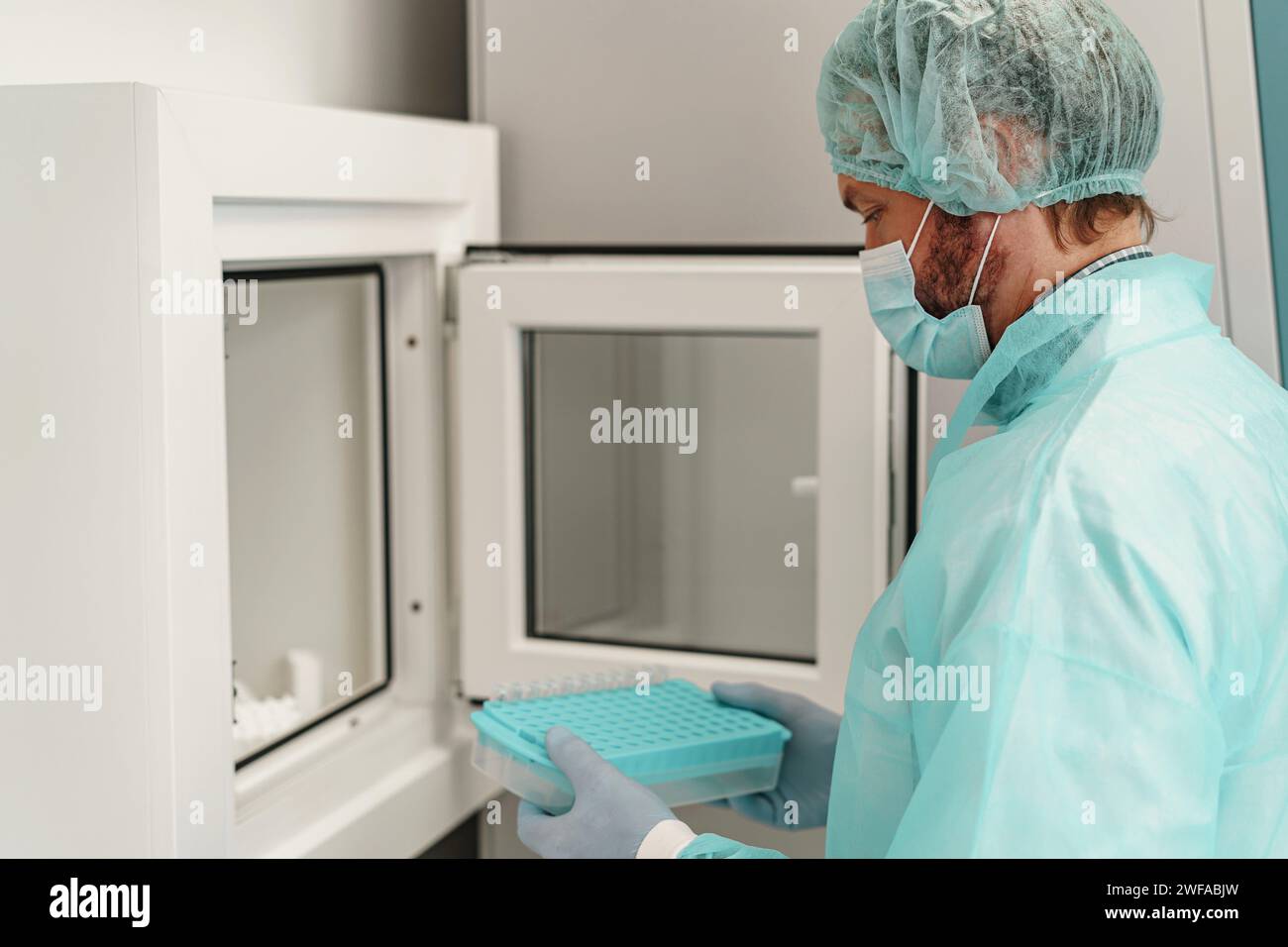 L'uomo scienziato in uniforme tiene le provette in laboratorio. Medicina e ricerca in chimica Foto Stock