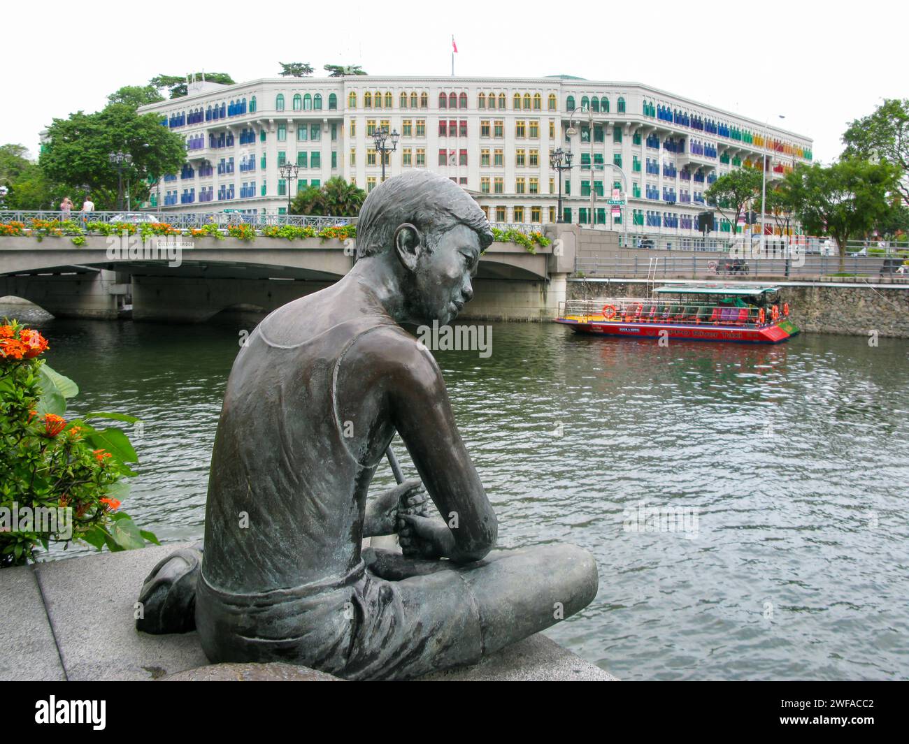 Il ragazzo e il suo cane statua di bronzo a Robertson Quay, sul fiume Singapore a Singapore. Foto Stock