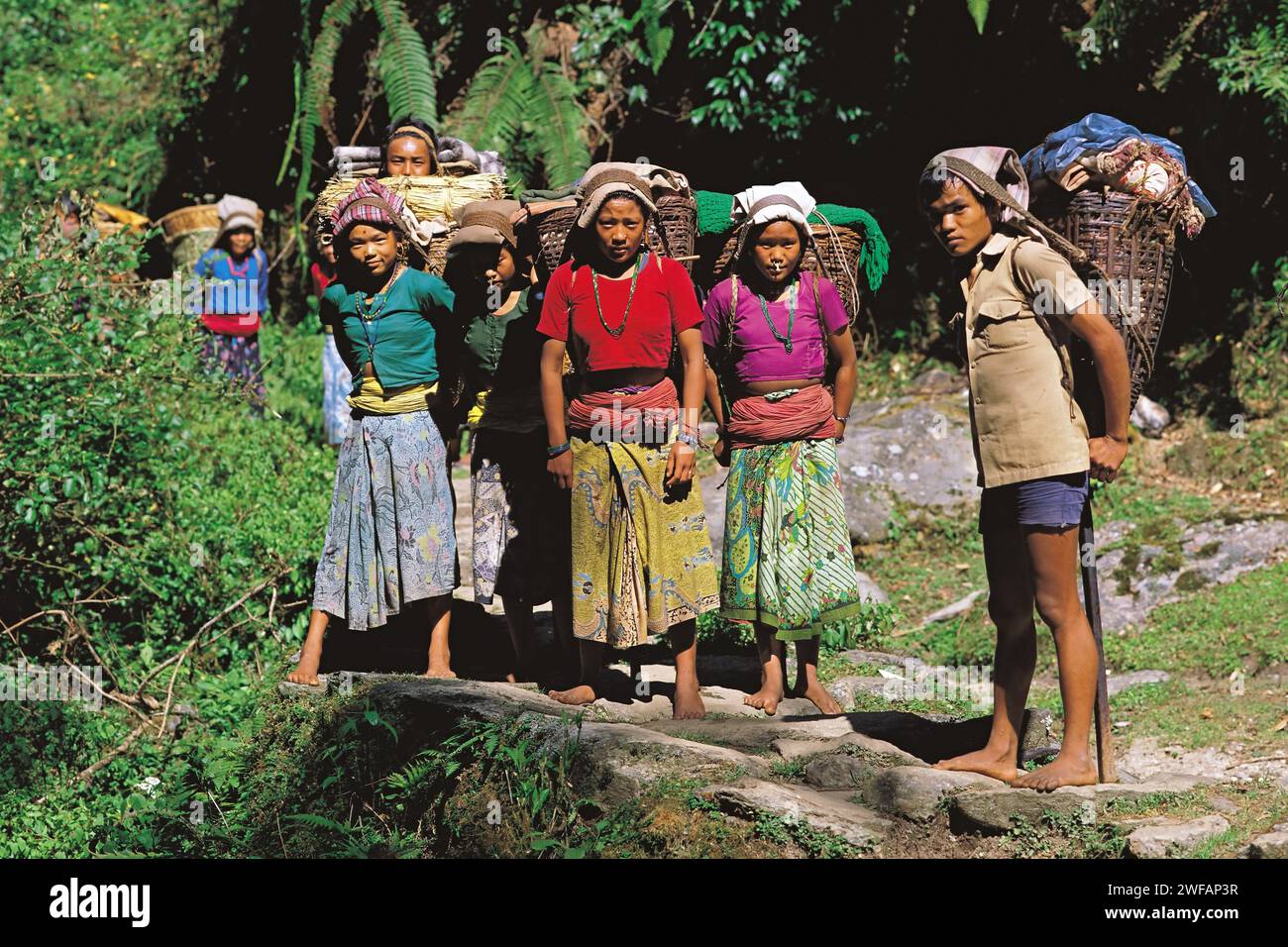 Gruppo di giovani in viaggio di scambio che trasportano merci al loro villaggio natale nella regione Makalu del Nepal orientale Foto Stock