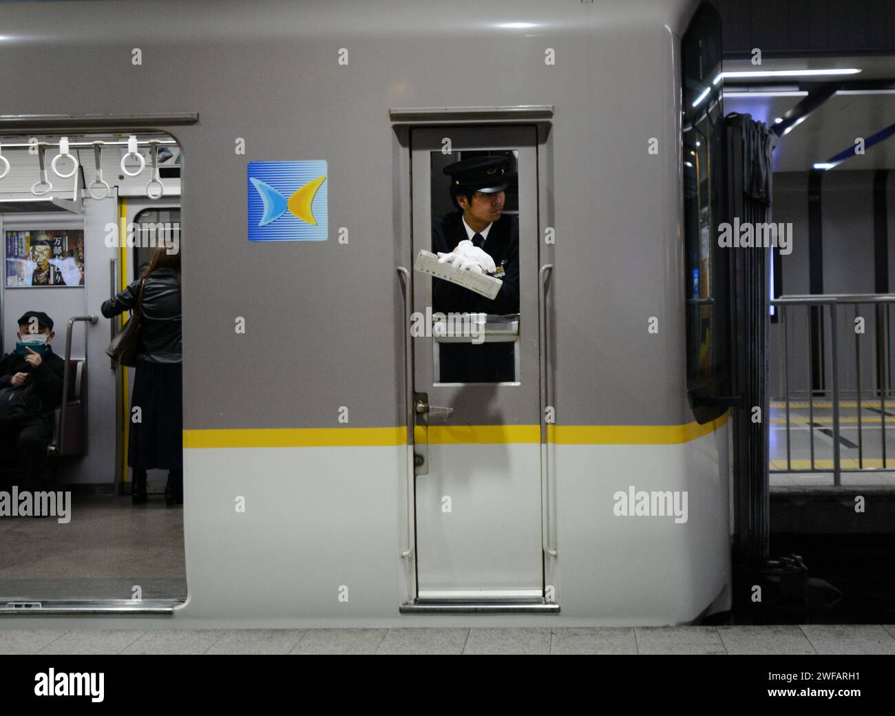 Un autista di treno giapponese nel treno locale nella stazione ferroviaria di Kobe, in Giappone. Foto Stock