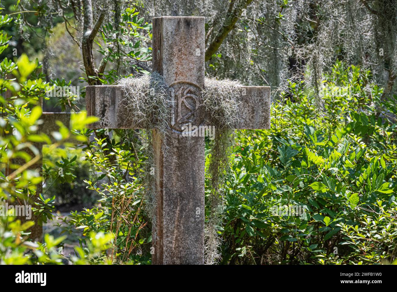 Croce di pietra drappeggiata con muschio spagnolo al cimitero di Bonaventure a Savannah, Georgia. (USA) Foto Stock