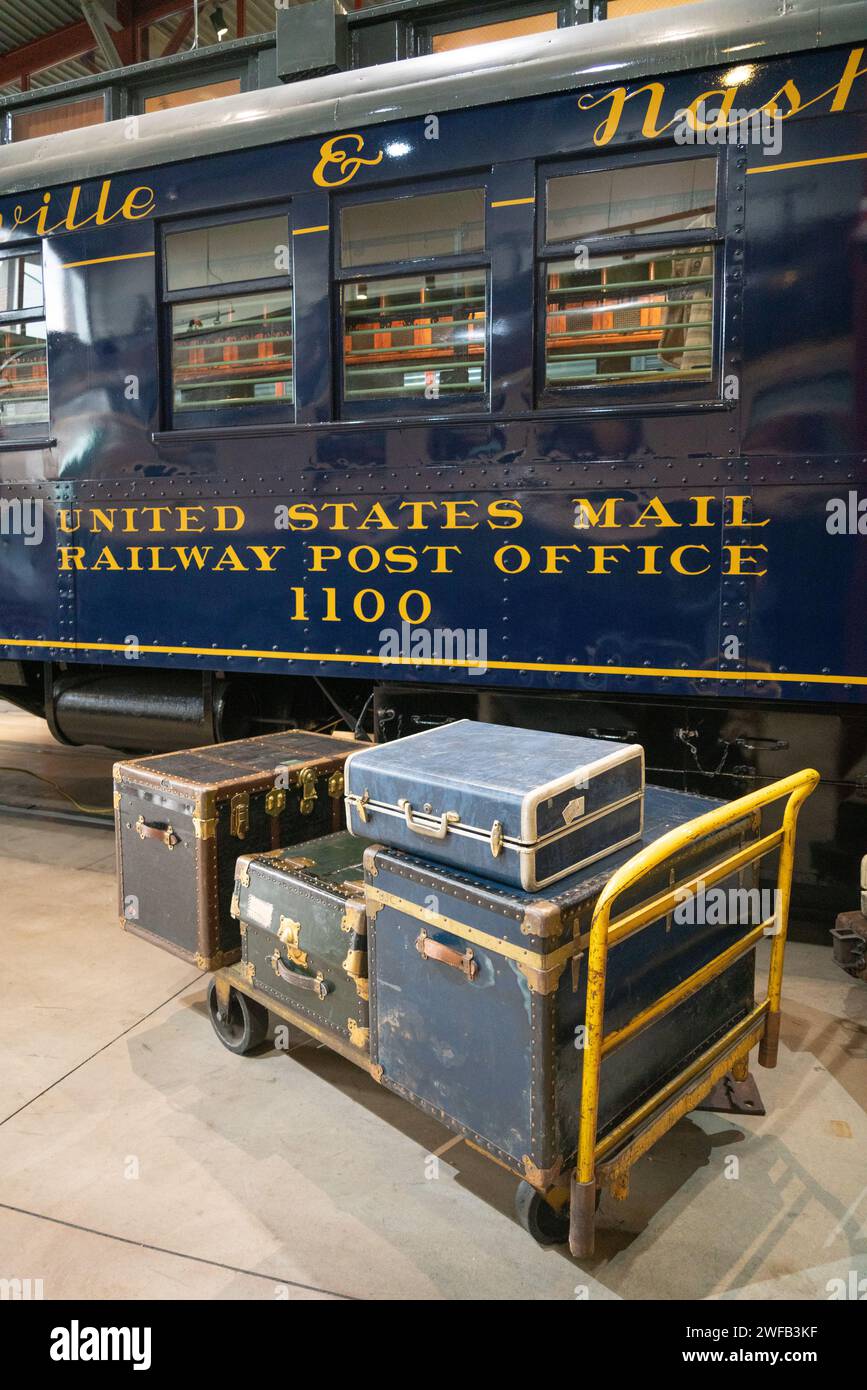 Un vecchio baule a vapore e un carrello per bagagli si trovano accanto a un vagone ferroviario della marina con la scritta Railway Post Office al Steamtown National Historic Site, Pennsylvania. Foto Stock