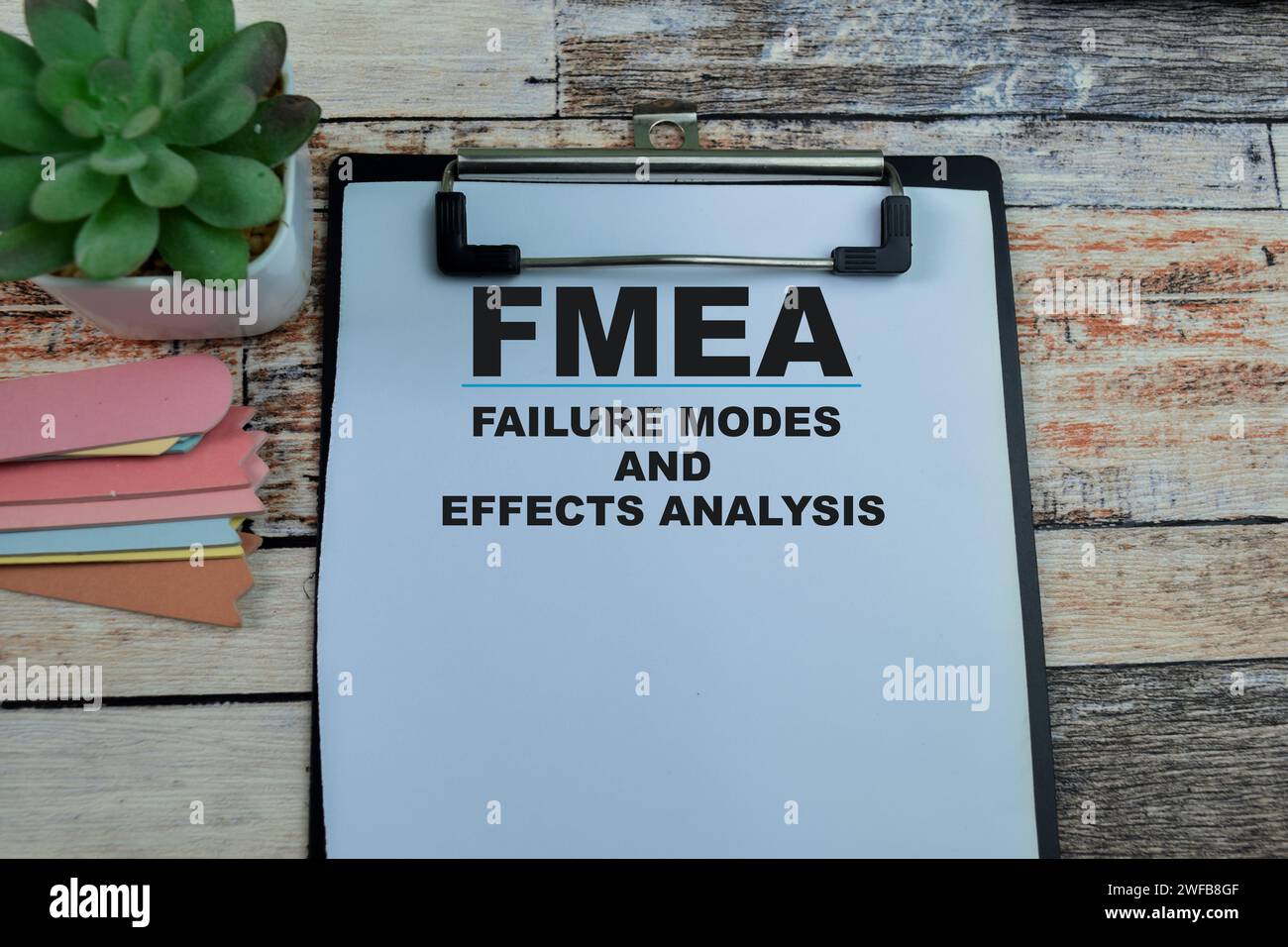 Concetto di FMEA - analisi degli effetti e delle modalità di fallimento scrittura su documenti isolati su sfondo di legno. Foto Stock