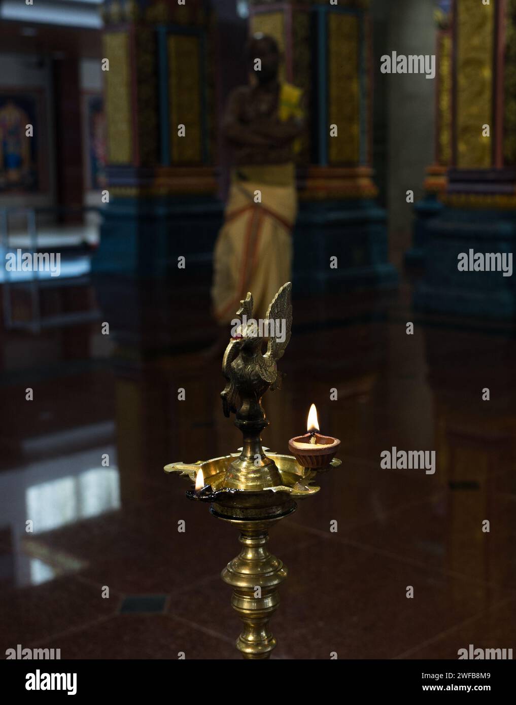 Una statua con le candele del tempio Foto Stock