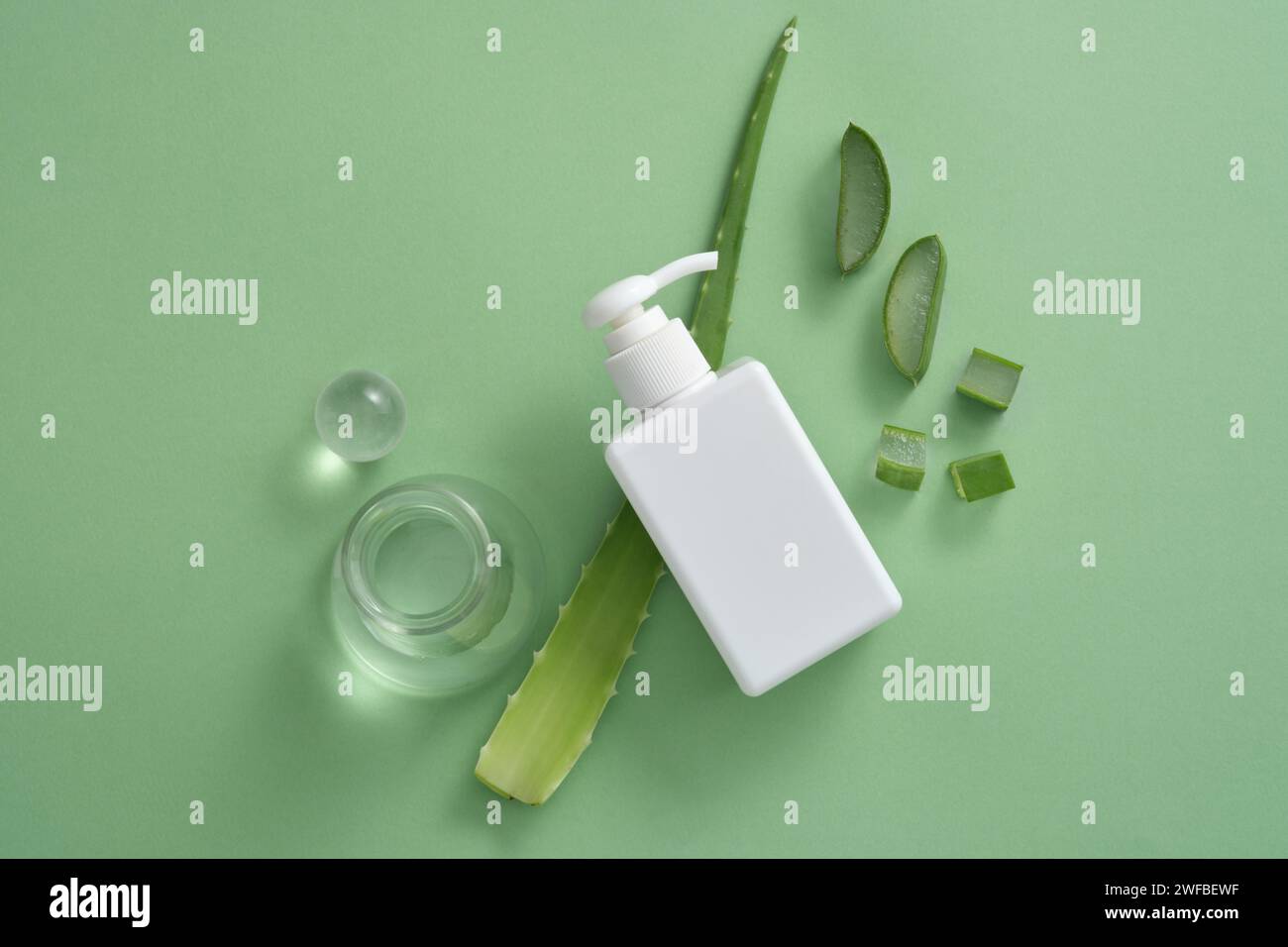 Dispenser a pompa per bottiglie con pallina di vetro, beuta di erlenmeyer e fette di Aloe vera. Utilizzo di prodotti per la cura dei capelli estratti dall'Aloe vera (Aloe barba Foto Stock