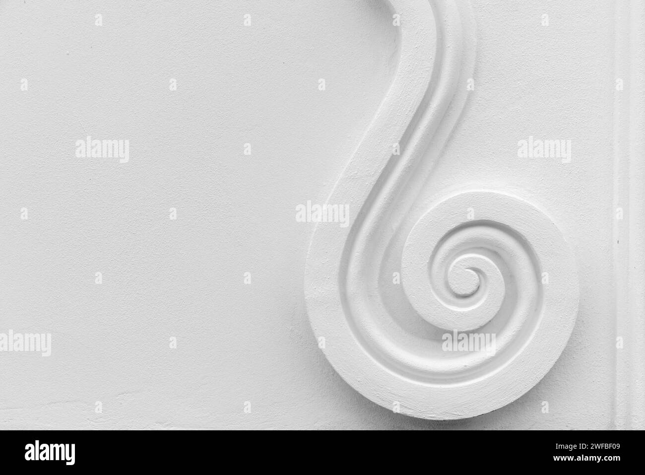 Foto astratta di sfondo dell'architettura classica, elemento decorativo a spirale su parete bianca Foto Stock