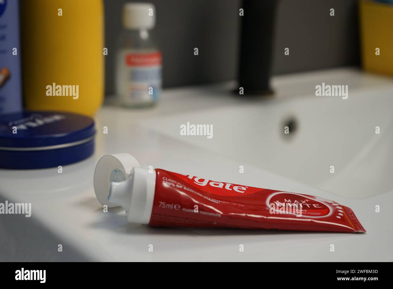 Dentifricio luminoso bianco Colgate Max per denti più bianchi ovunque e lotta contro la carie dentale e il tartaro dentale - tubo su un bancone del bagno Foto Stock