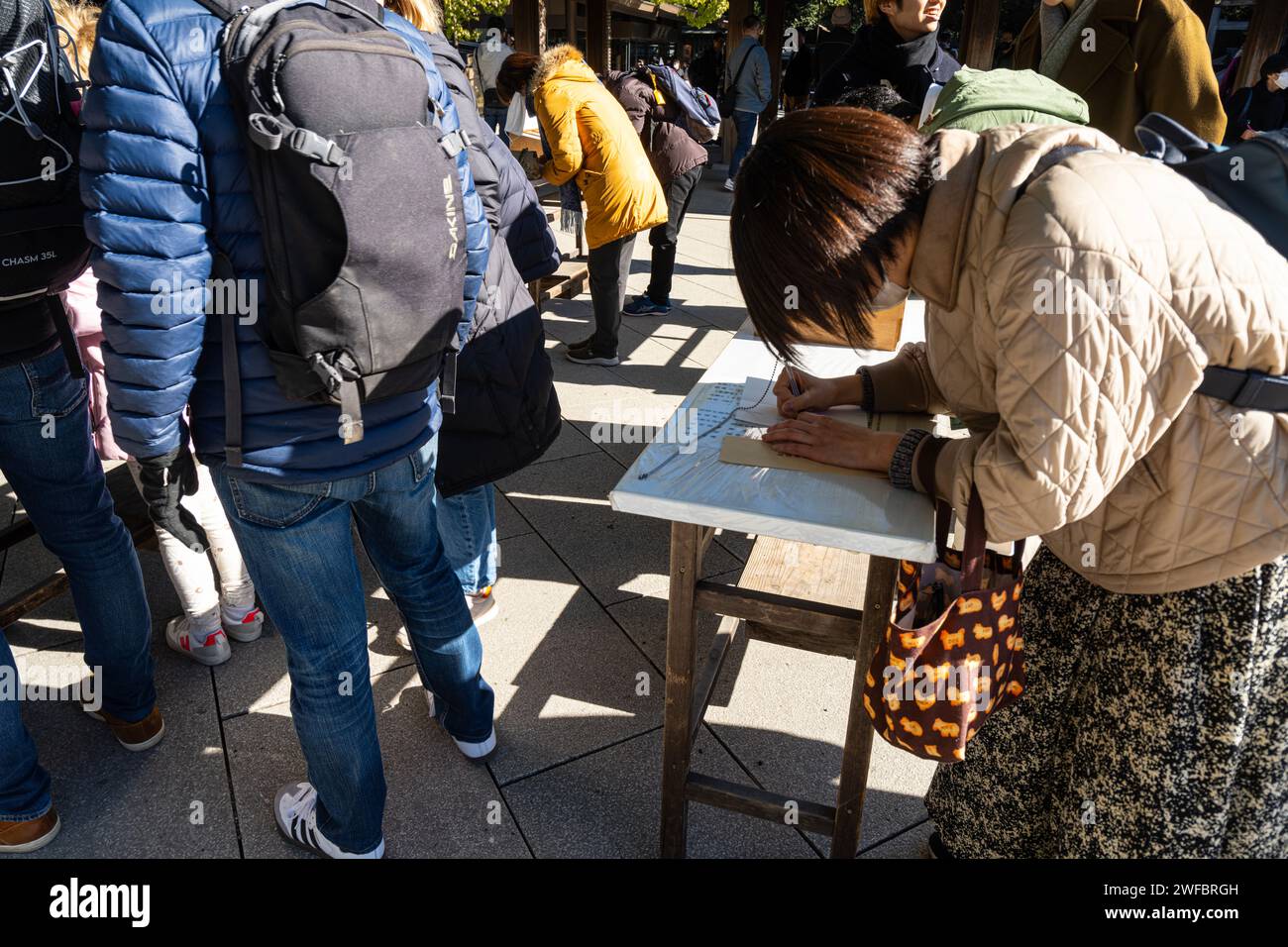 Tokyo, Giappone. 8 gennaio 2024. I fedeli mentre scrivono le tavolette di Ema, targhe di legno su cui i fedeli scrivono i desideri da indirizzare a questi Foto Stock