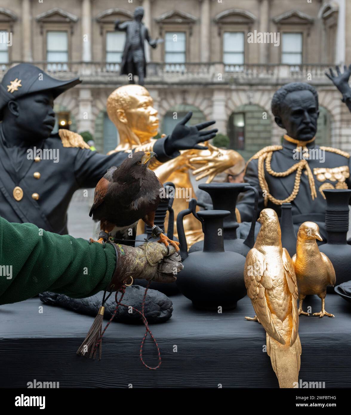 La Royal Academy, Londra, Regno Unito. 30 gennaio 2024. L'artista interdisciplinare Tavares Strachan (nato nel 1979, Nassau, Bahamas) svela la sua nuova scultura la prima cena, 2021-23 nel cortile Annenberg della Royal Academy. La prima cena è presentata nell'ambito della mostra Engled Pasts: 1768-Now: Art, Colonialism and Change, inaugurata il 3 febbraio 2024. L'installazione è visitata da Harris Hawk, Jet. Crediti: Malcolm Park/Alamy Live News Foto Stock