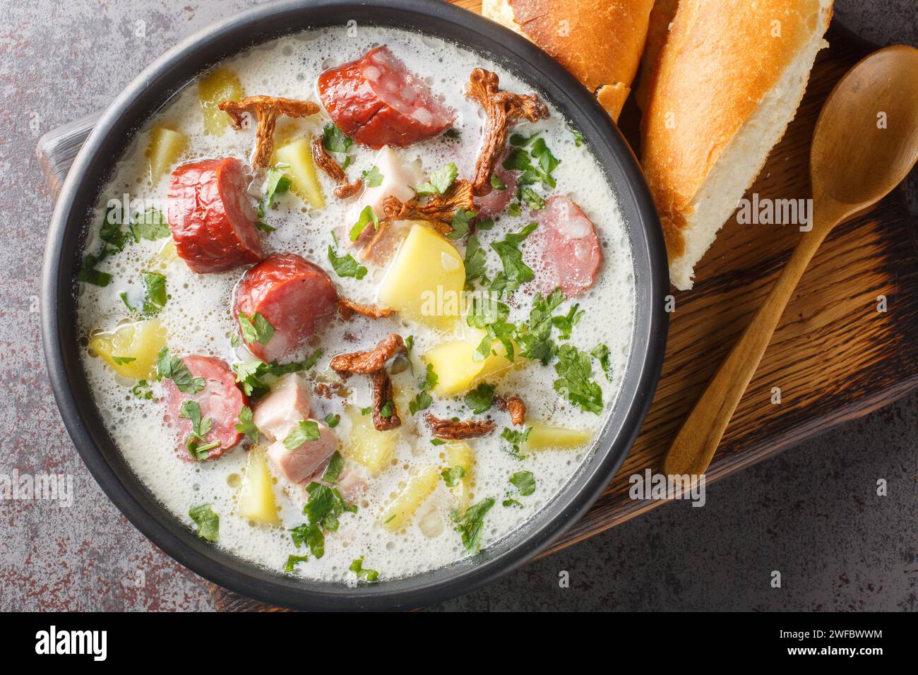 Zalewajka è una tradizionale zuppa rustica composta da patate a cubetti e bollite e ricoperta di pasta madre di segale acida con salsiccia e funghi secchi vicino Foto Stock