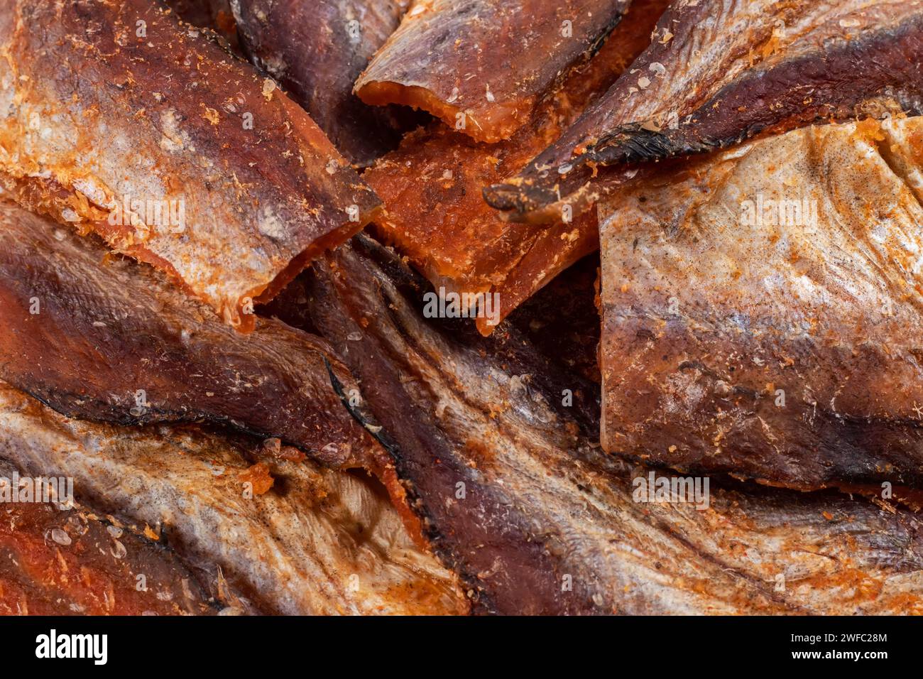 Pezzi di fondo di pesce secco pulito. Pollack piccante secco. Ambra con raccolta di peperoni. Foto Stock