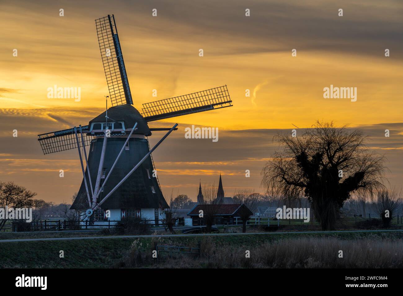 Abcoude, Paesi Bassi. Tipico paesaggio olandese con tradizionale mulino a vento al tramonto Foto Stock