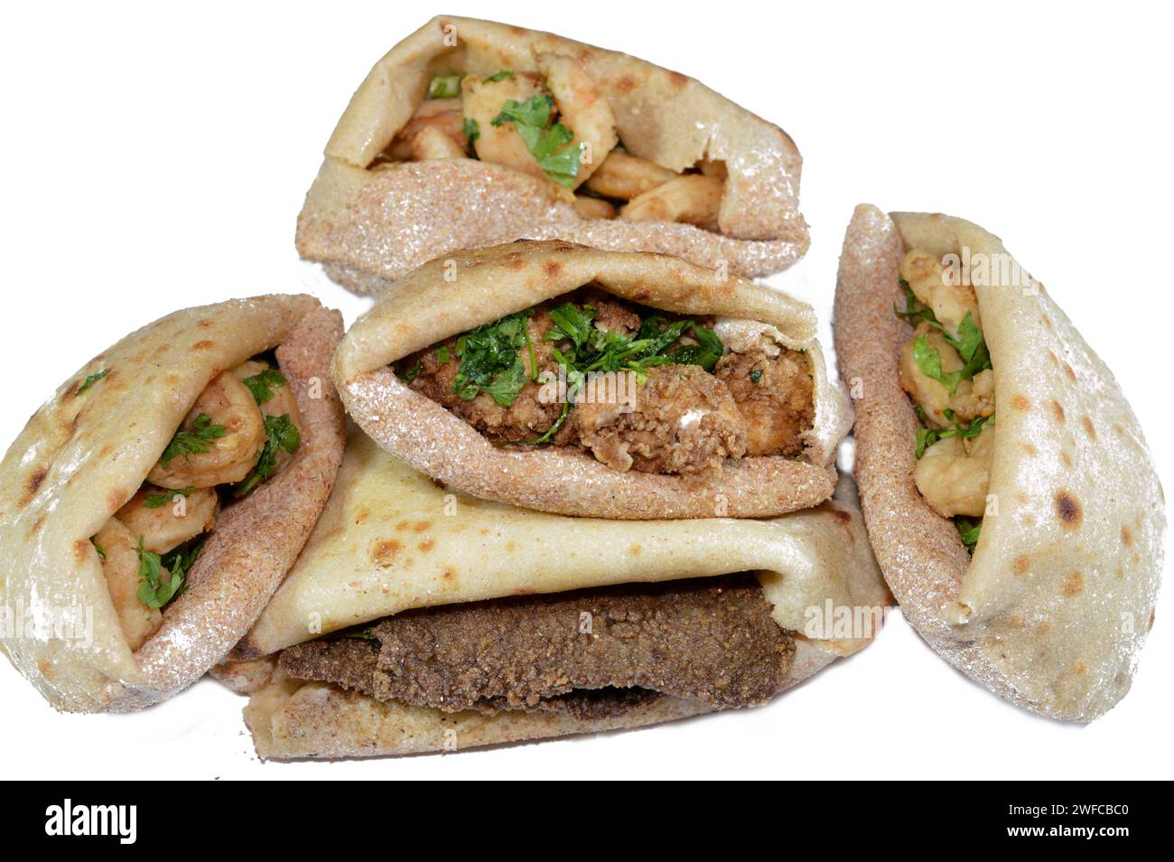 Sfondo di gamberetti fritti, cervello di manzo, fette di fegato di manzo fritte in olio e servite con prezzemolo in un tradizionale pane piatto egiziano con pancetta di grano Foto Stock