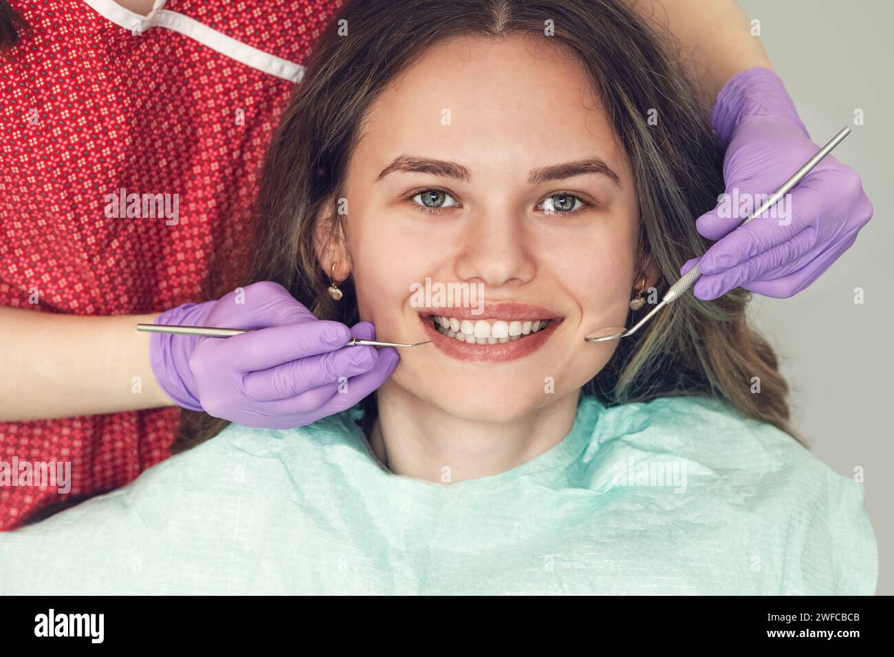 Dentista che esamina i denti del paziente in una clinica odontoiatrica durante il controllo della dentatura e della planatura delle radici Foto Stock