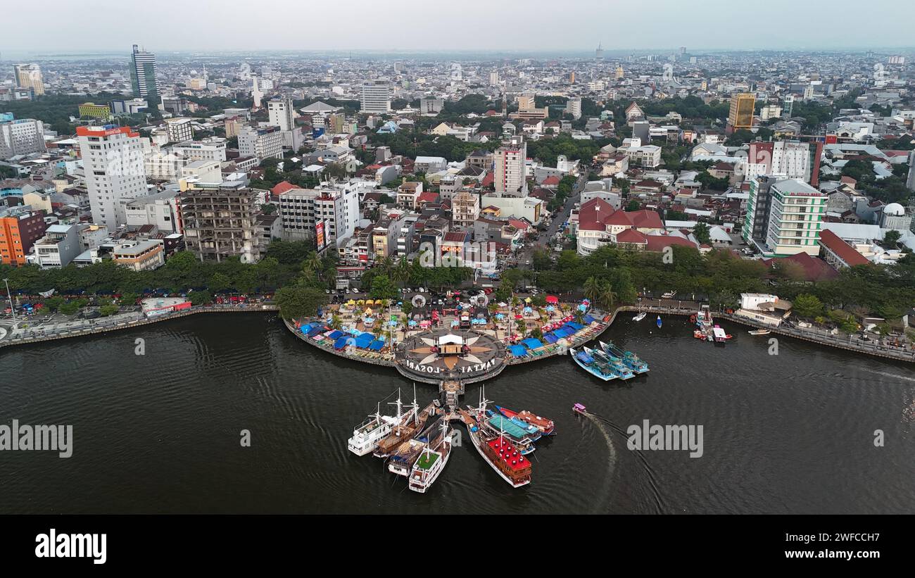Tela del porto cittadino: L'arazzo costiero di Makassar svelato in una Sinfonia aerea mozzafiato di colori e attività. Foto Stock