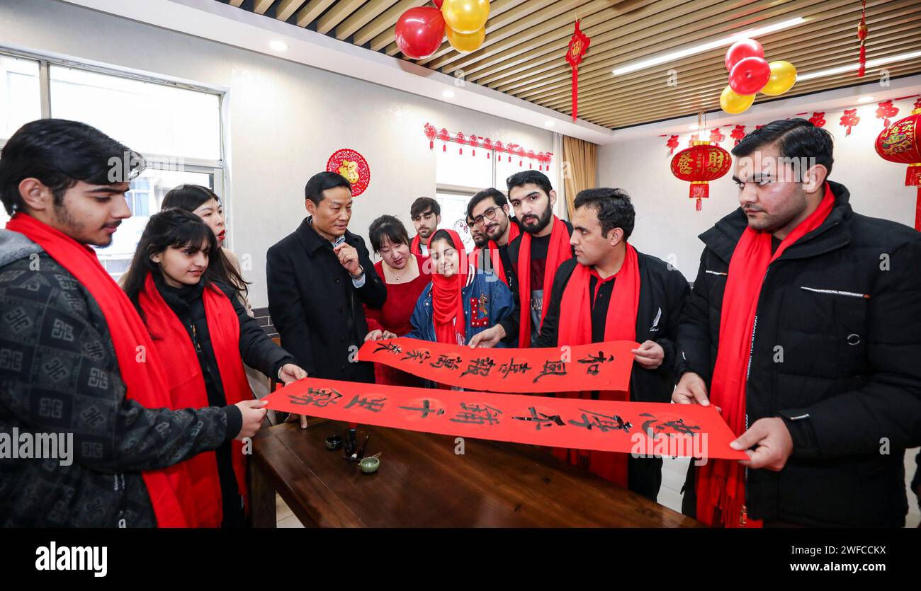 HUAI'AN, CINA - 30 GENNAIO 2024 - Un insegnante di calligrafia insegna agli studenti stranieri la cultura tradizionale cinese del capodanno nella città di Huai'an, East C Foto Stock