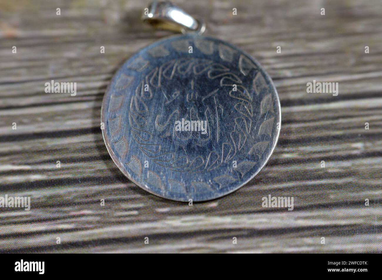 Traduzione del testo arabo (Allah, il Dio), il nome di Dio sul ciondolo d'argento, Silver è un elemento chimico Ag, trovato nella crosta terrestre in purezza Foto Stock