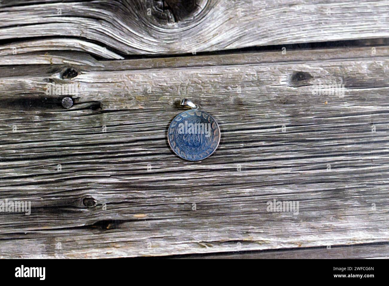 Traduzione del testo arabo (Allah, il Dio), il nome di Dio sul ciondolo d'argento, Silver è un elemento chimico Ag, trovato nella crosta terrestre in purezza Foto Stock