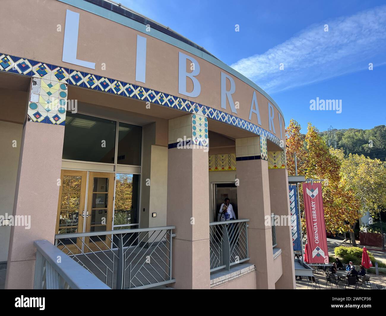 Ingresso alla Biblioteca Orinda con piastrelle decorative e striscioni, in una giornata limpida con foglie autunnali sullo sfondo, Orinda, California, 11 novembre 2023. Foto Stock