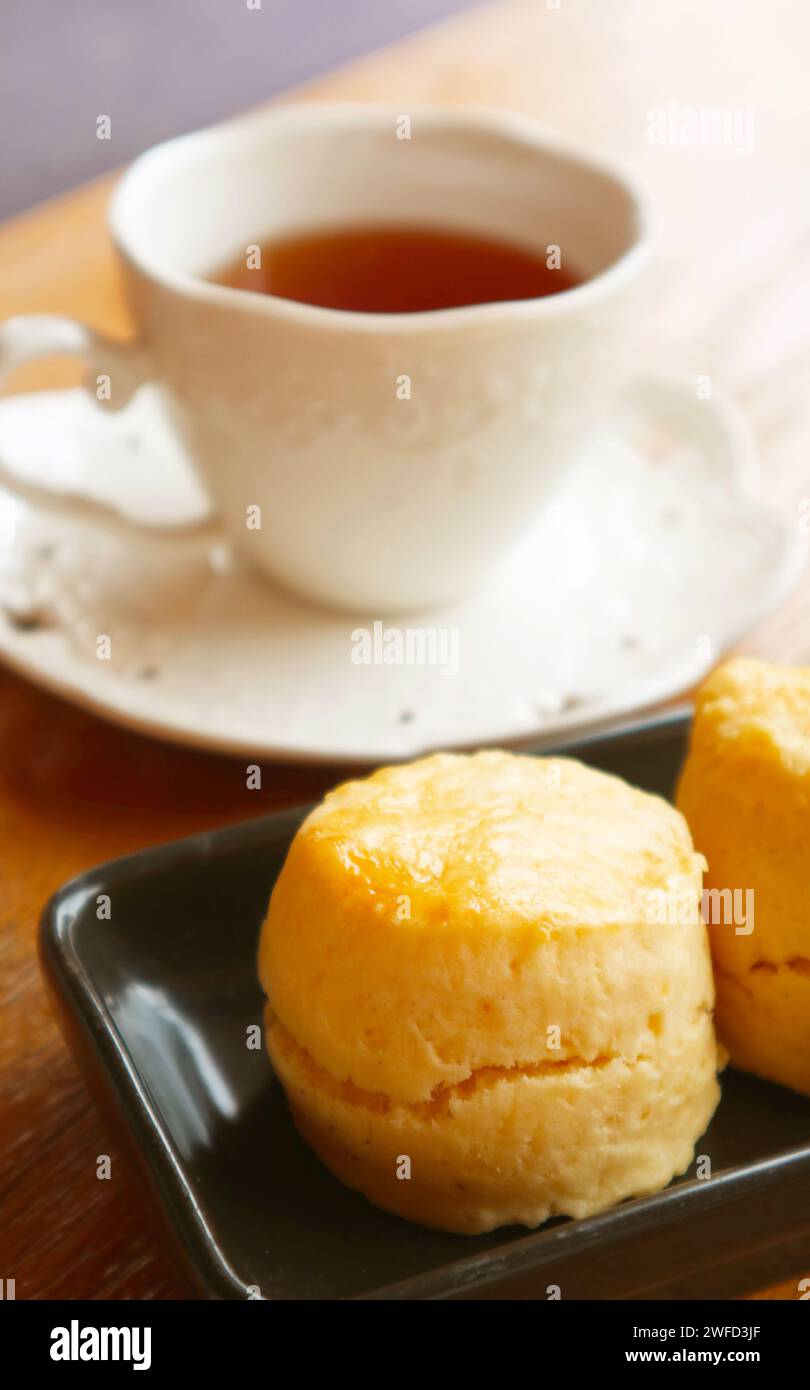 Primo piano di un delizioso cono con tazza da tè sfocata sullo sfondo Foto Stock