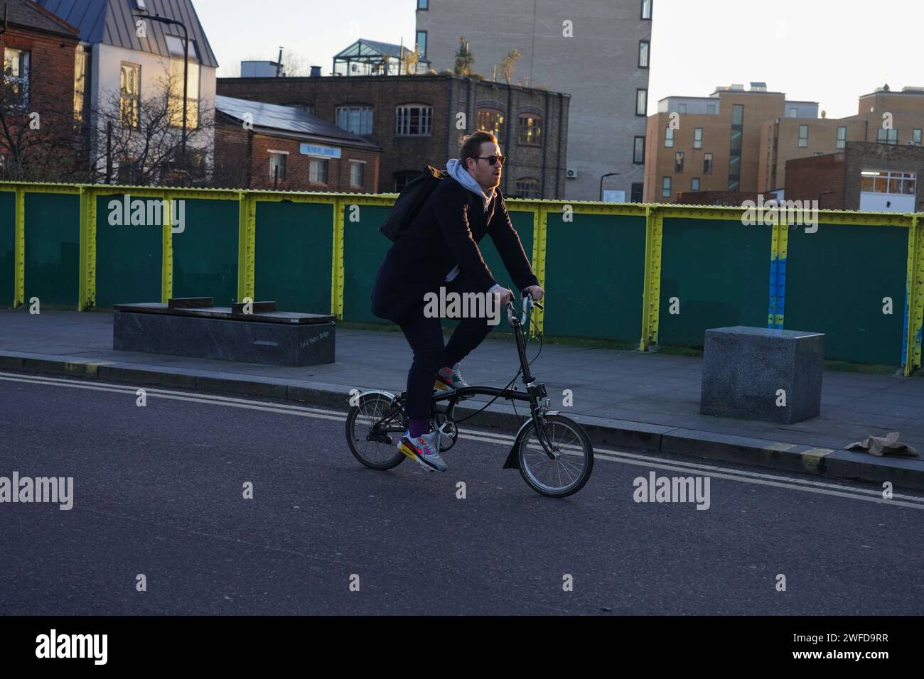 Un ciclista si sposta ad Hackney al sole della mattina presto d'inverno, attraversando il Regent's Canal. Foto Stock