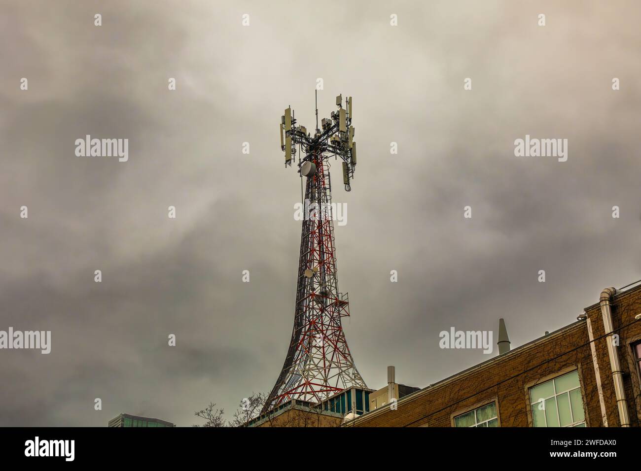 Una torre di comunicazione con microonde e cellulare in cima a un condominio   nel centro di Toronto. Foto Stock