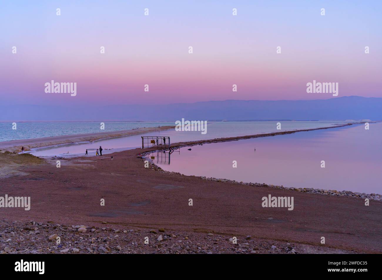 Ein Bokek, Israele - 19 gennaio 2024: Vista al tramonto della costa del Mar morto, con i visitatori, nel resort di Ein Bokek, nel deserto della Giudea, nel sud di Israele Foto Stock