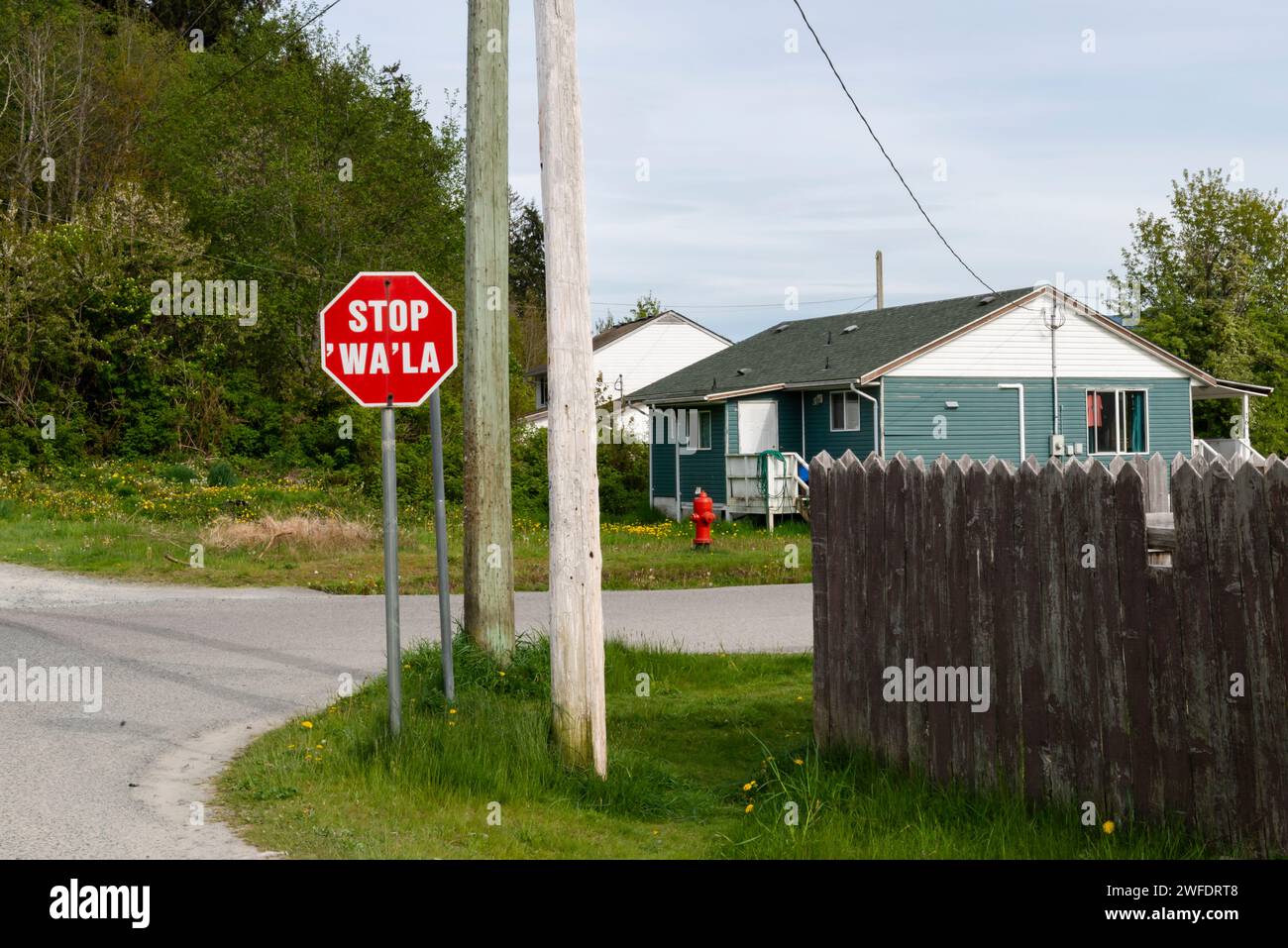 Un segnale di stop nella comunità Namgis First Nation include la lingua indigena, in un quartiere residenziale di Cormorant Island, nella Columbia Britannica Foto Stock