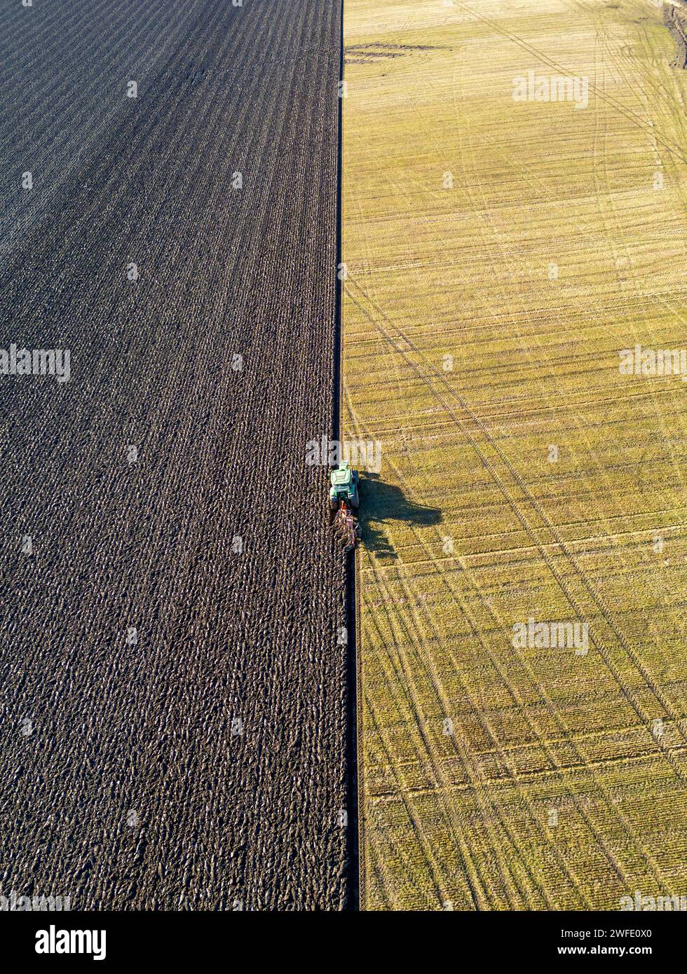 Vista aerea con droni di un trattore che ara un campo, Linlithgow, West Lothian, Scozia Foto Stock