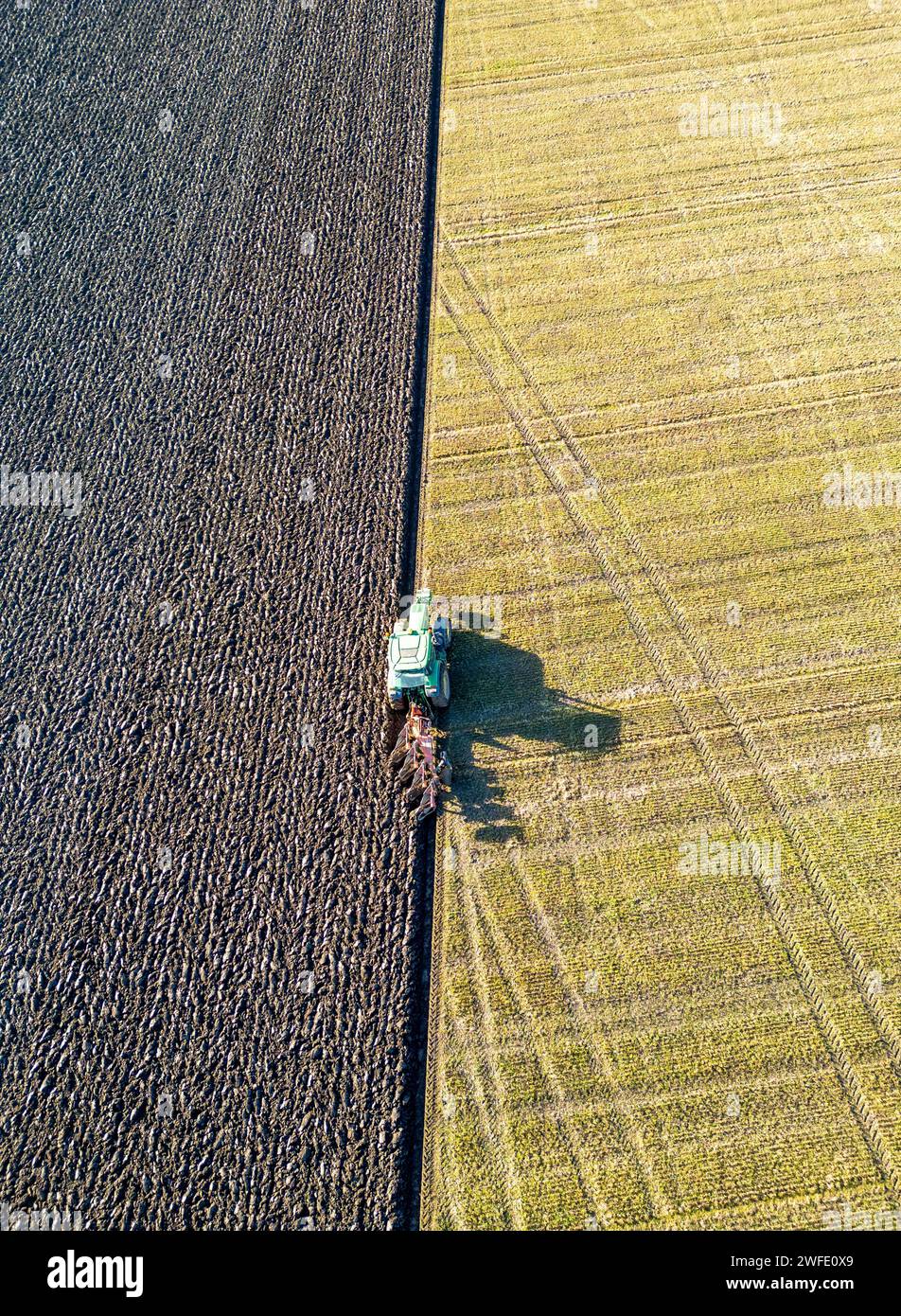 Vista aerea con droni di un trattore che ara un campo, Linlithgow, West Lothian, Scozia Foto Stock