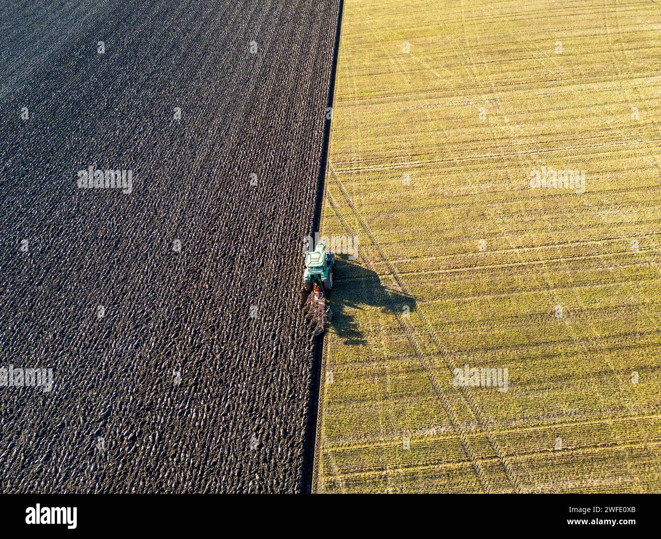 Vista aerea con droni di un trattore che ara un campo, Linlithgow, West Lothian, Scozia Foto Stock