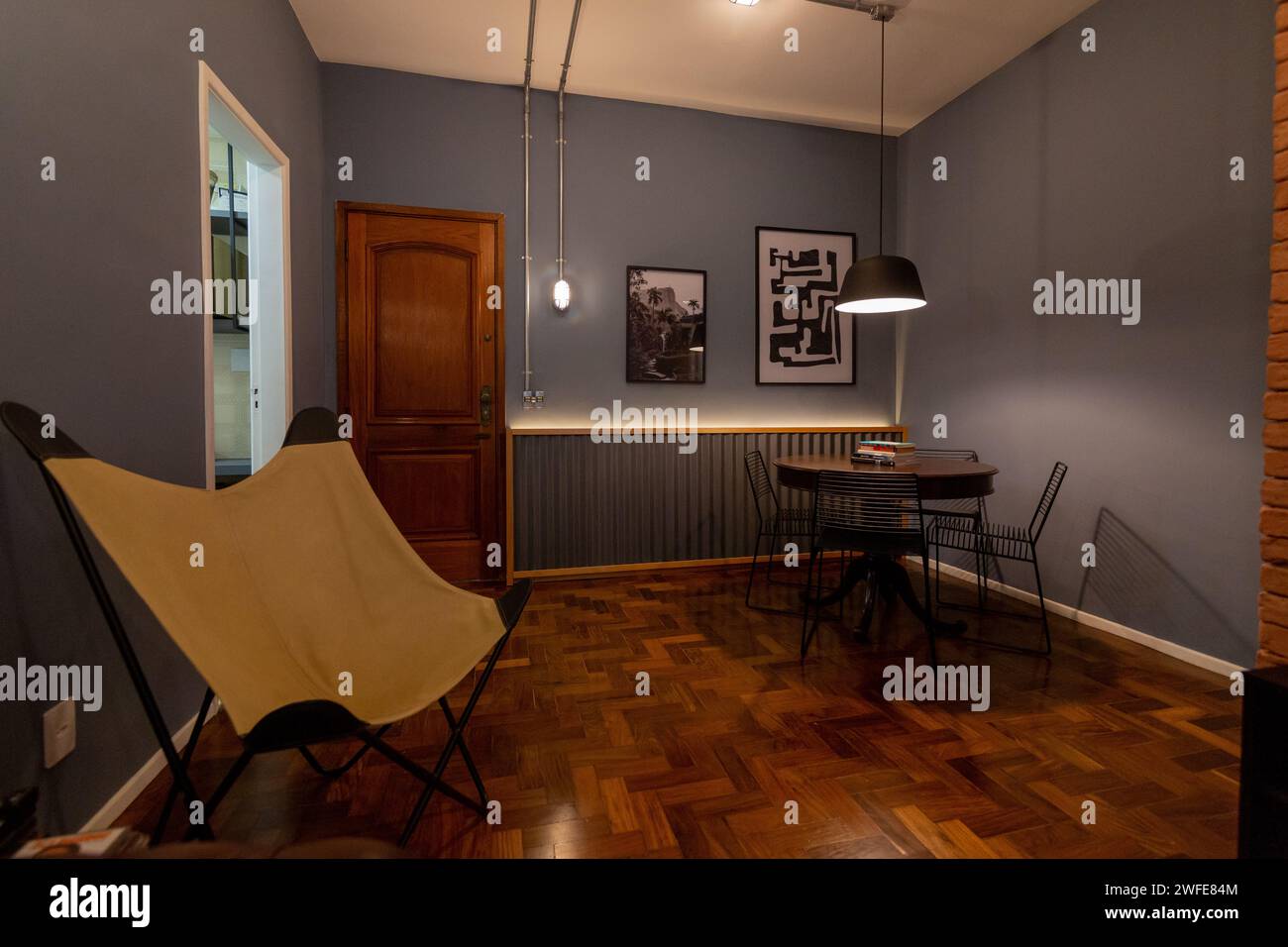 Camera accogliente con tavolo, sedie e pareti arredate Foto Stock