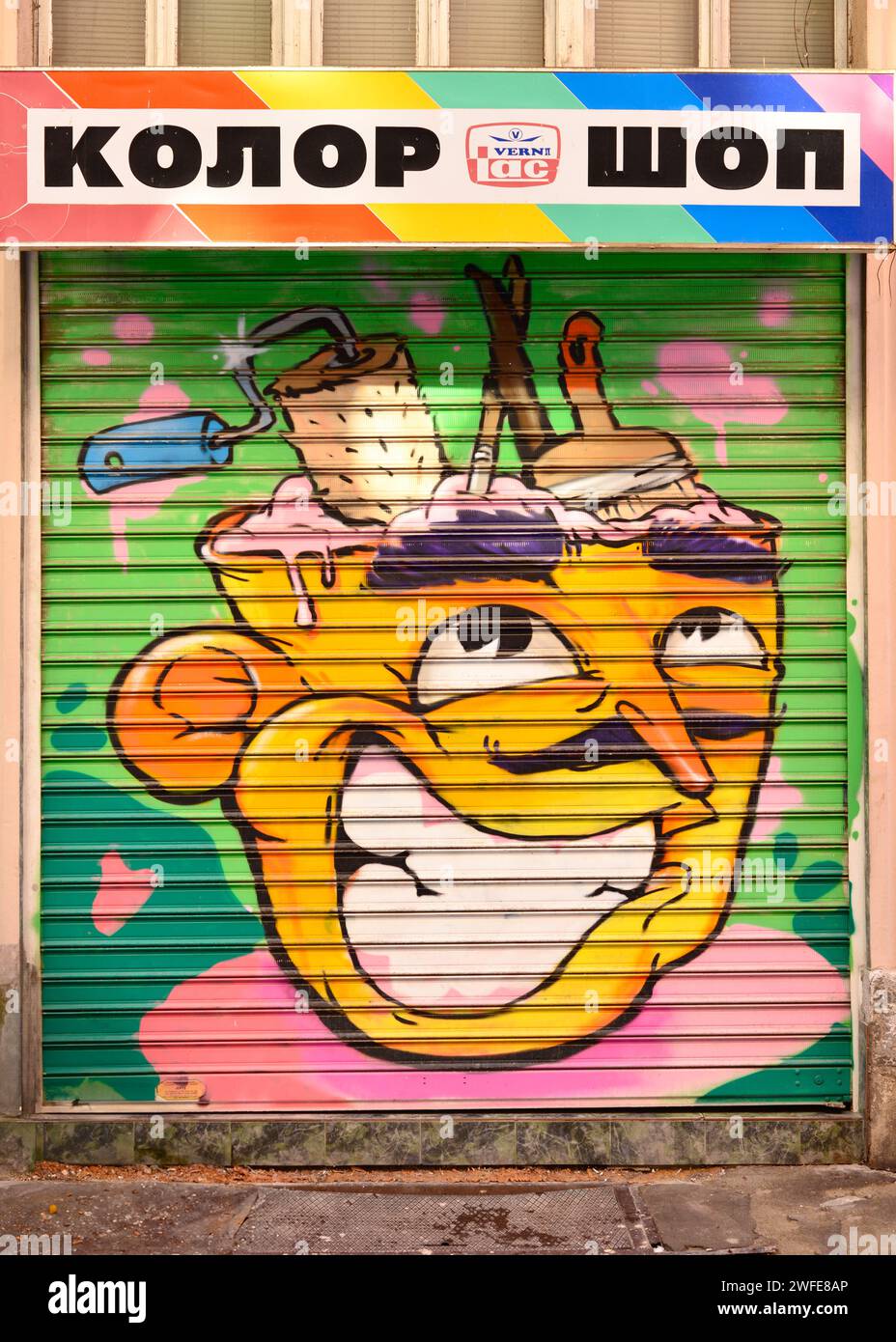 Testo colorato del negozio in cirillico e graffiti colorati su un piccolo negozio di vernici del quartiere locale con porte chiuse a Sofia, Bulgaria, Europa orientale, UE Foto Stock