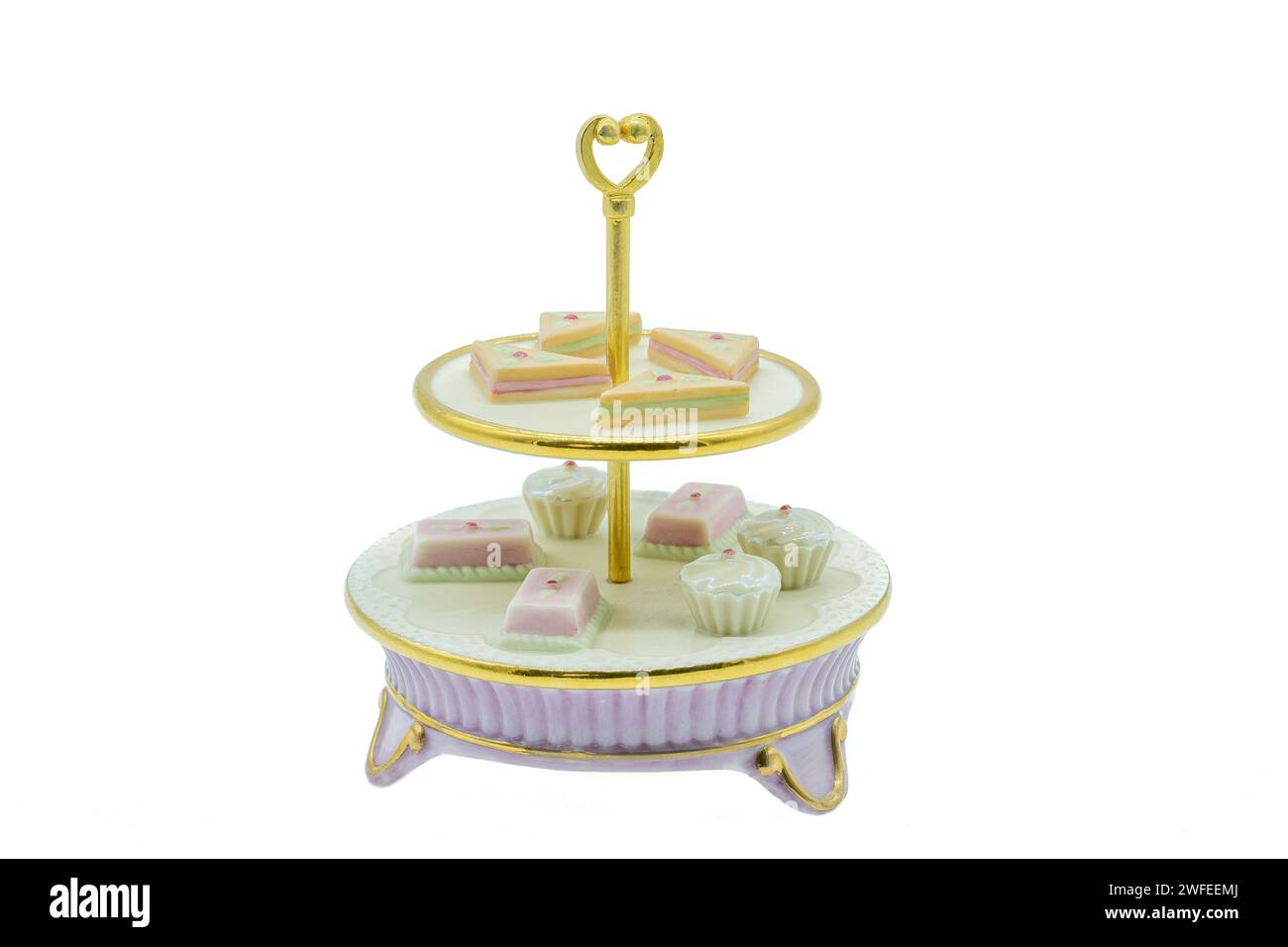 Banco per dolci pomeridiani in porcellana antica con bordature dorate e delicate torte ornamentali sui singoli livelli del banco per dolci. Foto Stock