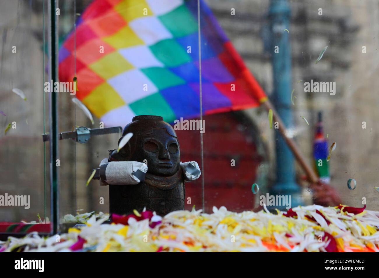 La Paz, BOLIVIA; 24 gennaio 2015. Un'antica illa (o statua) di un Ekeko (un dio Aymara dell'abbondanza) vista di fronte alla chiesa di San Francisco e una bandiera del wiphala mentre viene sfilata per le strade di la Paz per celebrare la sua prima apparizione al festival Alasitas, che inizia oggi. La statua ha circa 2000 anni ed è stata realizzata dalla cultura Pucara. È stato portato dal sito archeologico di Tiwanaku in Svizzera nel 1858, e restituito in Bolivia dal Museo di storia di Berna nel novembre 2014. Foto Stock