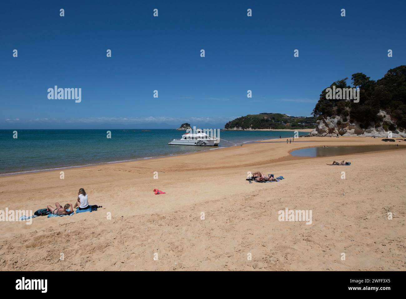 Barca e bagni di sole sulla spiaggia, Kaiteriteri Beach, Tasman, South Island, nuova Zelanda Foto Stock