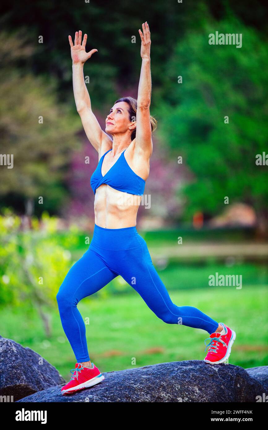 Atleta che si allena indossando abbigliamento sportivo tra i ciliegi Foto Stock